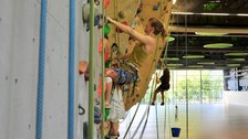 In der Sporthalle werden Klettergriffe ausgetauscht.