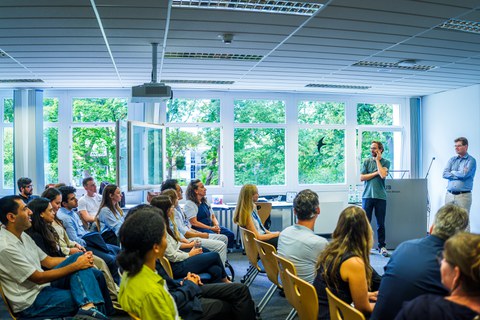 Gruppe sitzt in Stuhlreihen