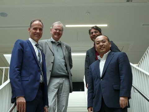 Four men standing on stairs