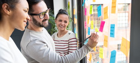 Business people meeting at office and use post it notes to share idea. Brainstorming concept. Sticky note on glass wall.