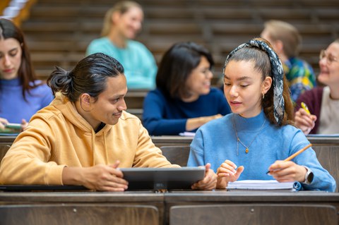 Photo of 7 students in the TUD lecture hall. They are working together or talking.