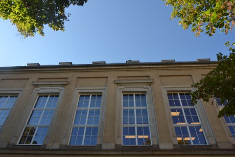 Vier große Fenster des Weberbaus. Durch sie sieht man Lampen an der Decke.