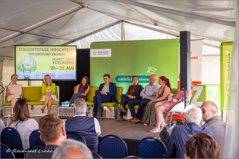 Podiumsdiskussion mit 7 Personen auf der Bühne in einem Zelt bei den Zukunftstagen Hirschfelde