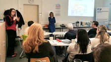 Projektleiterin Anke Langner spricht zum Publikum, im Hintergrund Schulleiterin Maxi Heß und die Präsentation zum Schulkonzept.