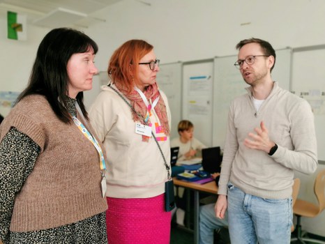 Schulleiterin Keller aus Seifhennersdorf mit einer Mitarbeiterin im Gespräch mit einem Lernbegleiter.