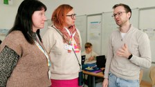 Schulleiterin Keller aus Seifhennersdorf mit einer Mitarbeiterin im Gespräch mit einem Lernbegleiter.