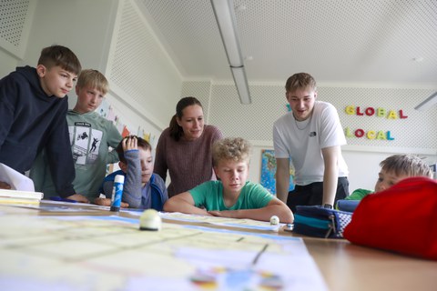 Schulleiterin Sabrina Hälschke und ein Student programmieren zusammen mit Schülern der Richard-von-Schlieben-Oberschule in Zittau Ozobot-Minicomputer.