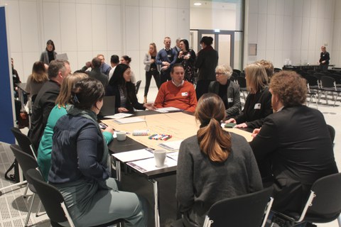 Eindrücke aus dem Workshop: Teilnehmenden diskutieren am Tisch