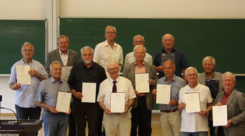 Absolventen halten 50 Jahre nach ihrem Abschluss ihre Urkunde "Gold-Diplom" in den Händen
