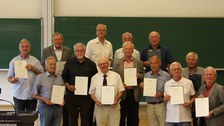 Absolventen halten 50 Jahre nach ihrem Abschluss ihre Urkunde "Gold-Diplom" in den Händen