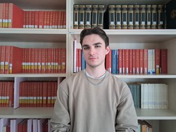 Dominik Pogrzeba vor Bücherregal
