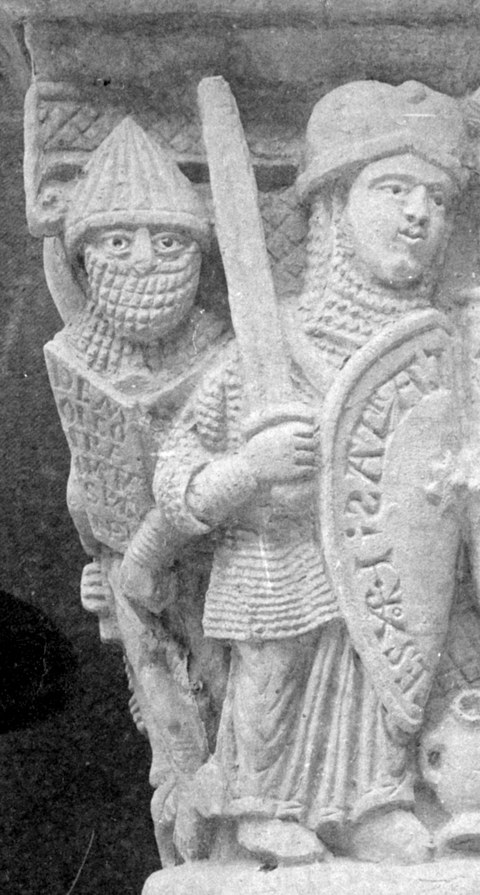 Auf dem Bild sind zwei Skulpturen zu sehen, die in Rüstung gekleidet sind. Der vordere Ritter trägt ein Schwert und ein Schild in der Hand.