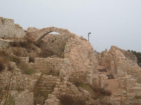 Zu sehen ist eine alte Ruine aus Sandstein, die stark zerfallen ist. 