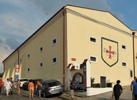 Auf dem Bild ist ein gelbes Gebäude mit einem roten Kreuz zu sehen. 