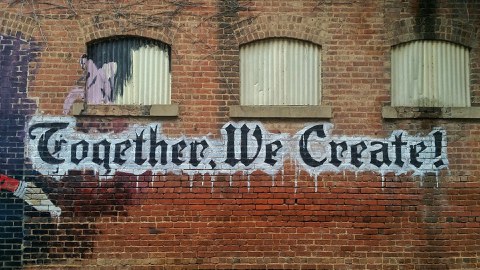 Logo "Together We Create" auf Hauswand