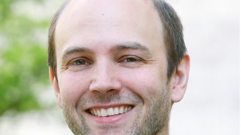Portrait photo of Dr. Johan Horst wearing a dark blue jacket and light blue shirt.