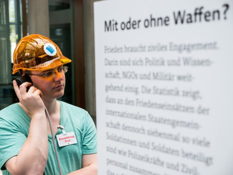 Eine Gruppe geht durch die Ausstellung Frieden Machen 