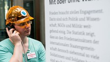 Eine Gruppe geht durch die Ausstellung Frieden Machen 