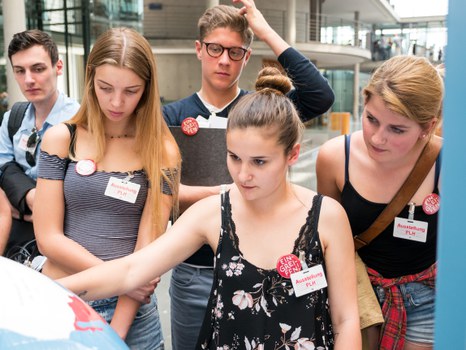 Eine Gruppe geht durch die Ausstellung Frieden Machen 