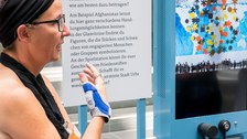Eine Gruppe geht durch die Ausstellung Frieden Machen 