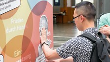 Eine Gruppe geht durch die Ausstellung Frieden Machen 