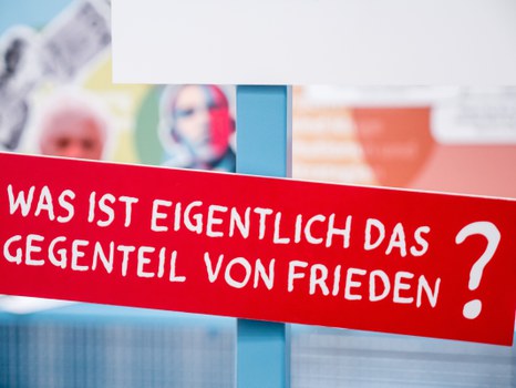 Eine Gruppe geht durch die Ausstellung Frieden Machen 