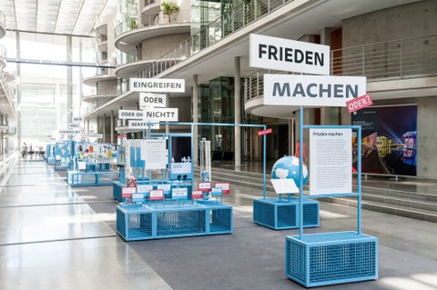 Eine Gruppe geht durch die Ausstellung Frieden Machen 