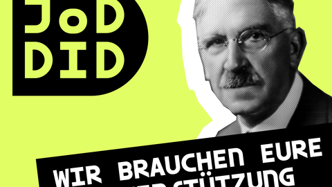 John Dewey mit Schild "Wir brauchen Unterstützung"