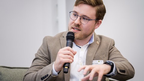 Janek Treiber spricht mit Mikrofon in der Hand.