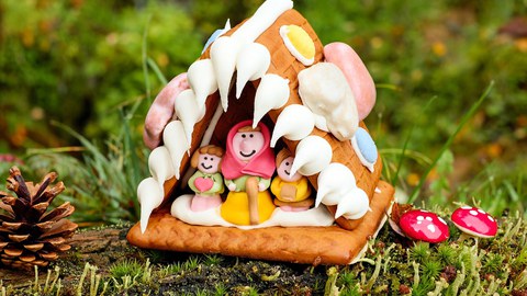 Lebkuchenhaus mit Figuren, symbolisiert die Geschichte von Hänsel und Gretel