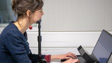 Eine junge Frau am Eyetracker, das Kinn in einer Stütze