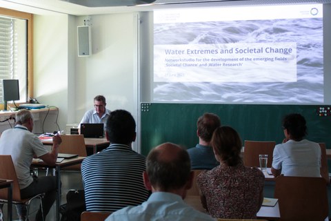Seminarraum mit Präsentation, Startfolie: "Water Extremes and Societal Change"