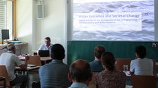 Seminarraum mit Präsentation, Startfolie: "Water Extremes and Societal Change"