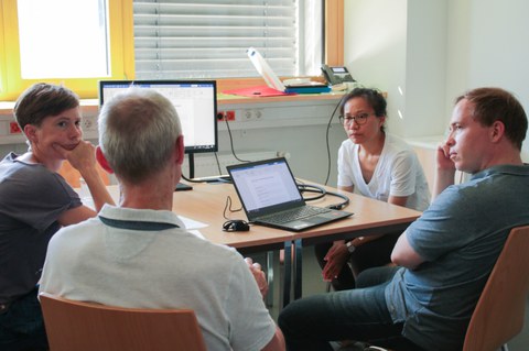 Gruppenarbeit: Teilnehmende sitzen um einen Tisch