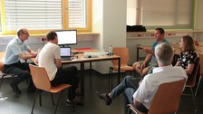 Gruppenarbeit: Eine Gruppe Teilnehmender um einen Tisch