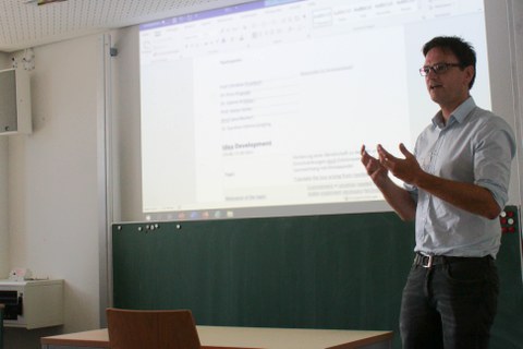 Präsentator vor einer unscharfen Folie