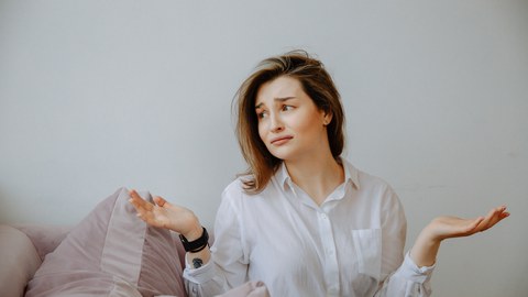 Zu sehen ist eine Frau, die ihre Hände nach oben hält. 