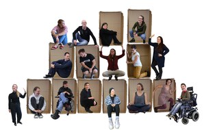 Auf dem Foto sitzen die Personen des QuaBIS Leipzig Teams in Pappkartons, die wie eine Pyramide gestapelt sind.