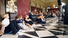 Guests are seated at tables and on the floor at Café Algarotti in the Semper Building.