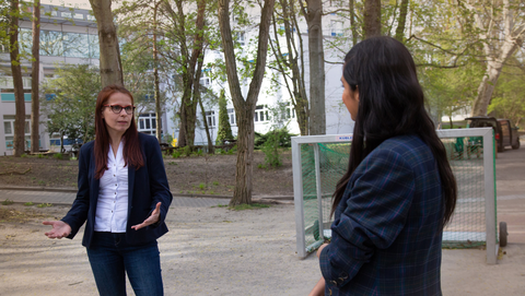 Prof. Dr. Anke Langner und Collien Ulmen Fernandes stehen auf dem Schulhof und unterhalten sich mit Corona-Sicherheitsabstand.