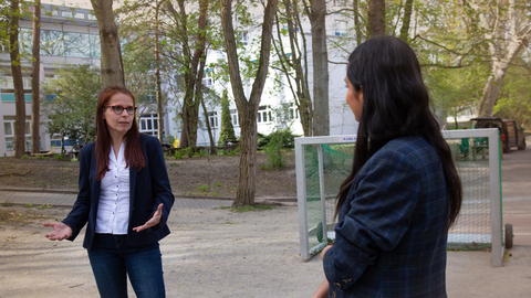 Prof. Dr. Anke Langner und Collien Ulmen Fernandes stehen auf dem Schulhof und unterhalten sich mit Corona-Sicherheitsabstand.