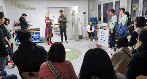 Headmistress Maxi Heß and a translator talk to a Korean delegation in a primary school classroom.