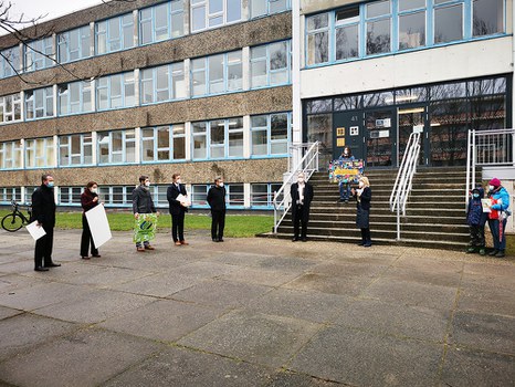 Auf dem Platz vor der Universitätsschule stehen Bildungsbürgermeister Jan Donhauser, Prof. Anke Langner, Elternrat Ulrich Puhlfürst, Mitglied des Universitätsschule Dresden e.V. Prof. Stefan Kornhuber, Prorektor Bildung der TU Dresden Michael Kobel, Oberbürgermeister Dirk Hilbert und Schulleiterin Maxi Heß mit Mund-Nasenschutz und Abstand.