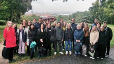 Etwa 30 Personen stehen vor dem regnerischen Panorama des TUD-Campus mit Blick auf den Weberbau.