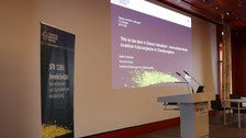 Leere Bühne mit Stehpult und Beamerpräsentation des Vortrags von Prof. Dr. Heike Greschke und Youmna Fouad