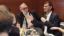 Prof. Dr. Gerd Schwerhoff stellt während der Diskussionsrunde nach Albrecht Dröses Vortrag eine Frage. Der danebensitzende Prof. Dr. Jürgen Müller hört diesem aufmerksam zu