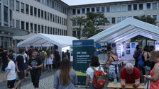 Blick in den Hof des Falkenbrunnen, zu sehen sind der Vortrags- und der Besucherpavillon mit Besuchern