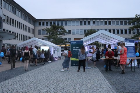 Blick in den Hof des Falkenbrunnen, zu sehen sind der Vortrags- und der Besucherpavillon mit Besuchern