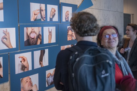 Foto von der Vernissage - Besucher betrachten Bilder an der Wand