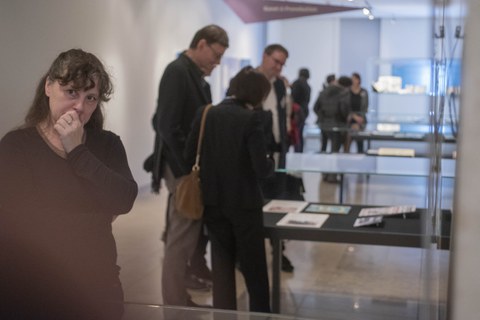 Foto von der Vernissage - Besucher betrachten eine Vitrine
